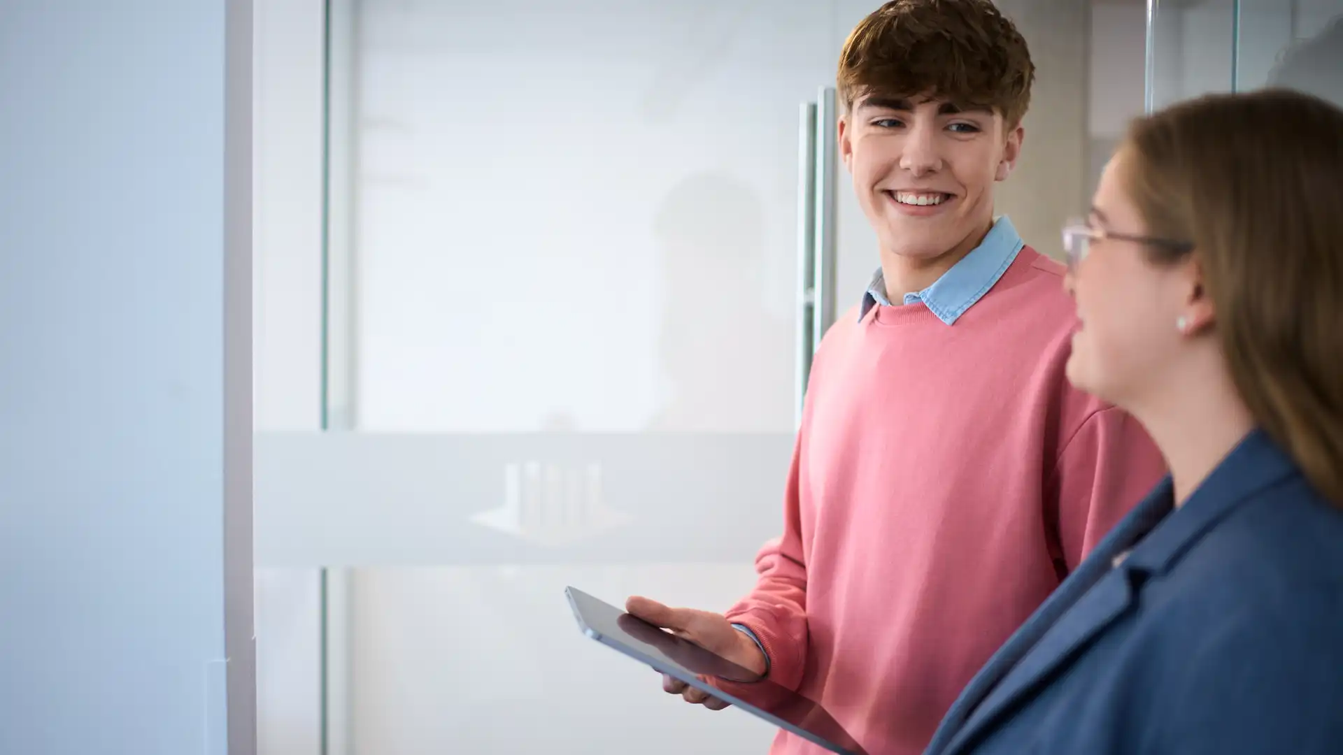 Zwei junge Mitarbeiter unterhalten sich.