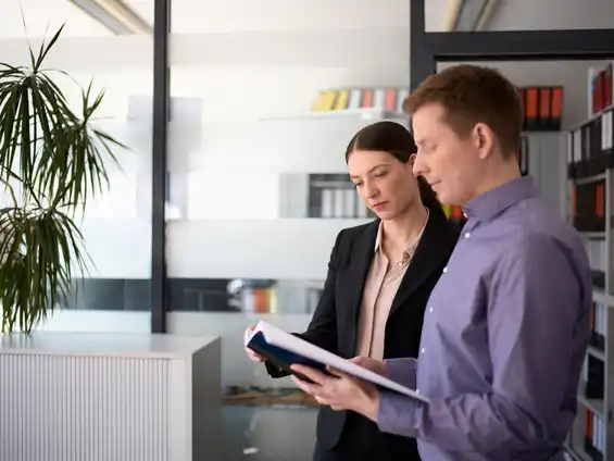 Ein Mann und eine Frau stehen vor einem Aktenschrank