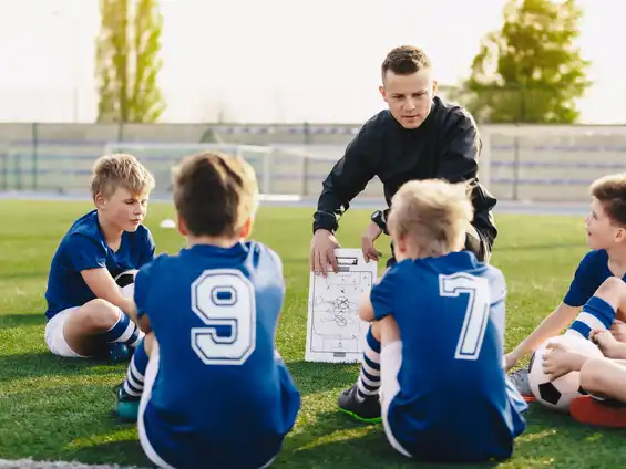 Ein Trainer, der mit einer jungen Fussballmannschaft spricht